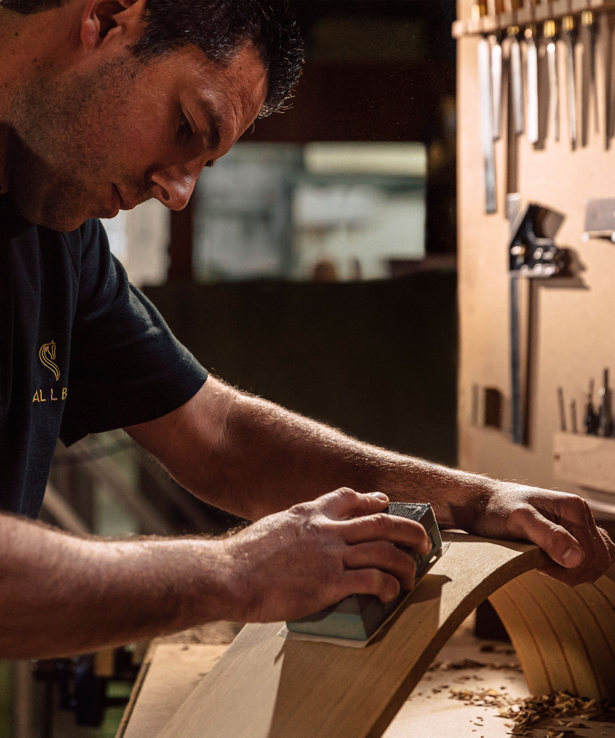 A Smallbone craftsman at his workbench sanding cabinetry