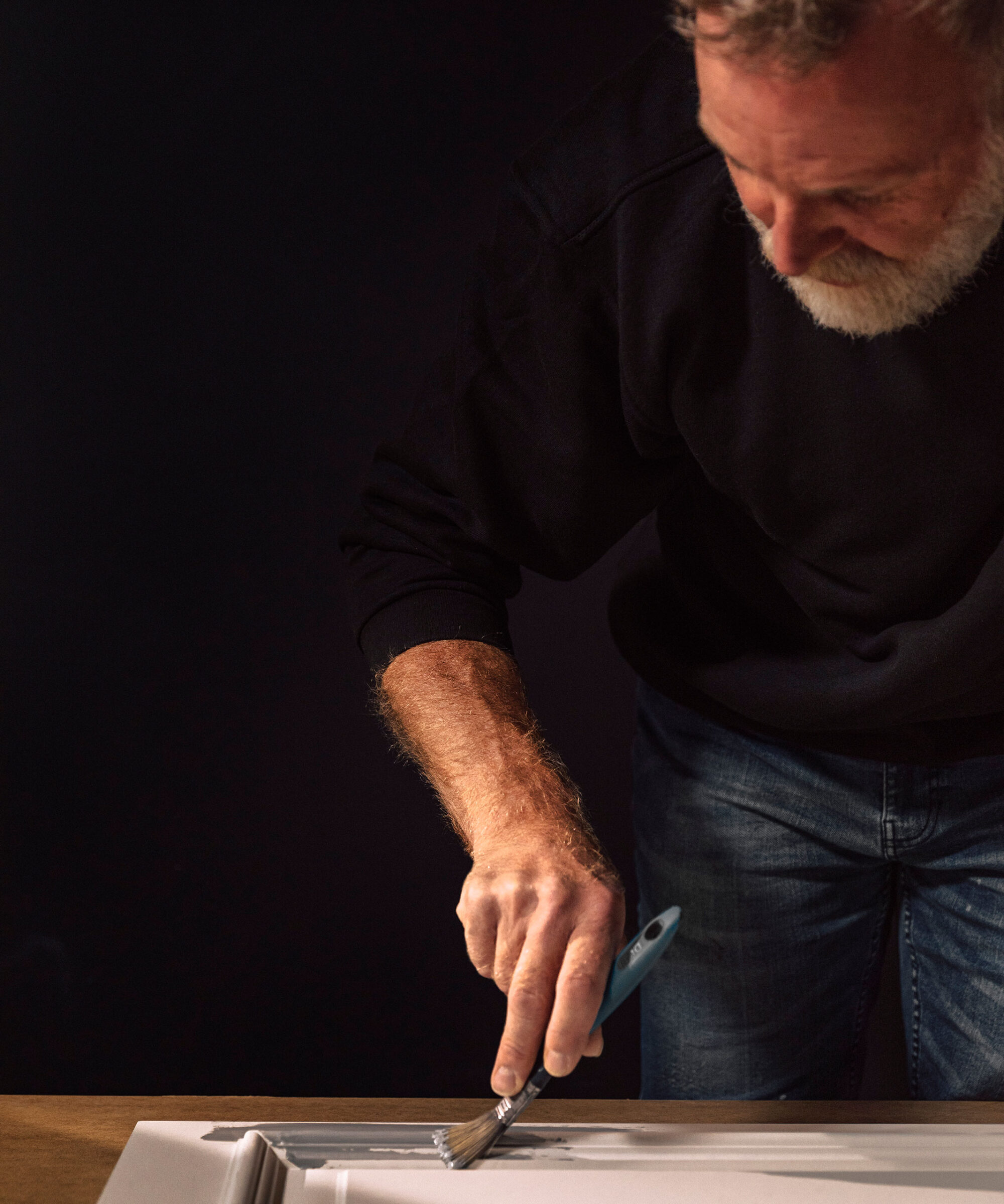 a Smallbone craftsman hand-painting a cabinet front