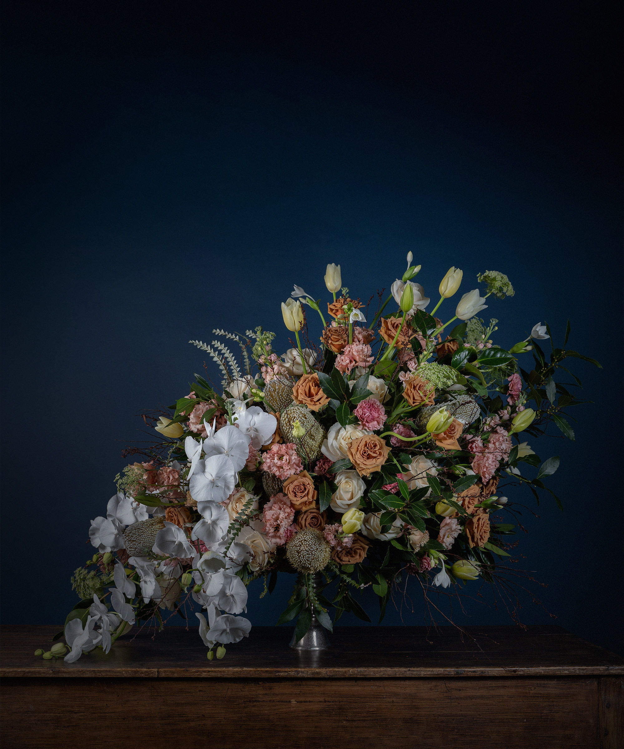 Mcqueens Flowers floral display on a wooden surface